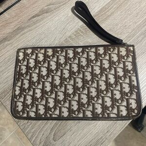 Oblique clutch bag with a brown logo on a beige background - Christian Dior logo